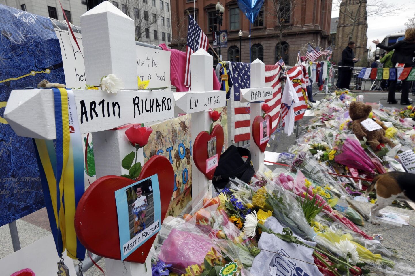 Memorials for Martin Richard, Lingzi Lu and Krystle Campbell, killed in the Boston Marathon bombings, stand among other artifacts at a memorial in Boston's Copley Square. The crosses and other items from the memorial are part of the exhibit opening April 7 in the Central Library in Copley Square.