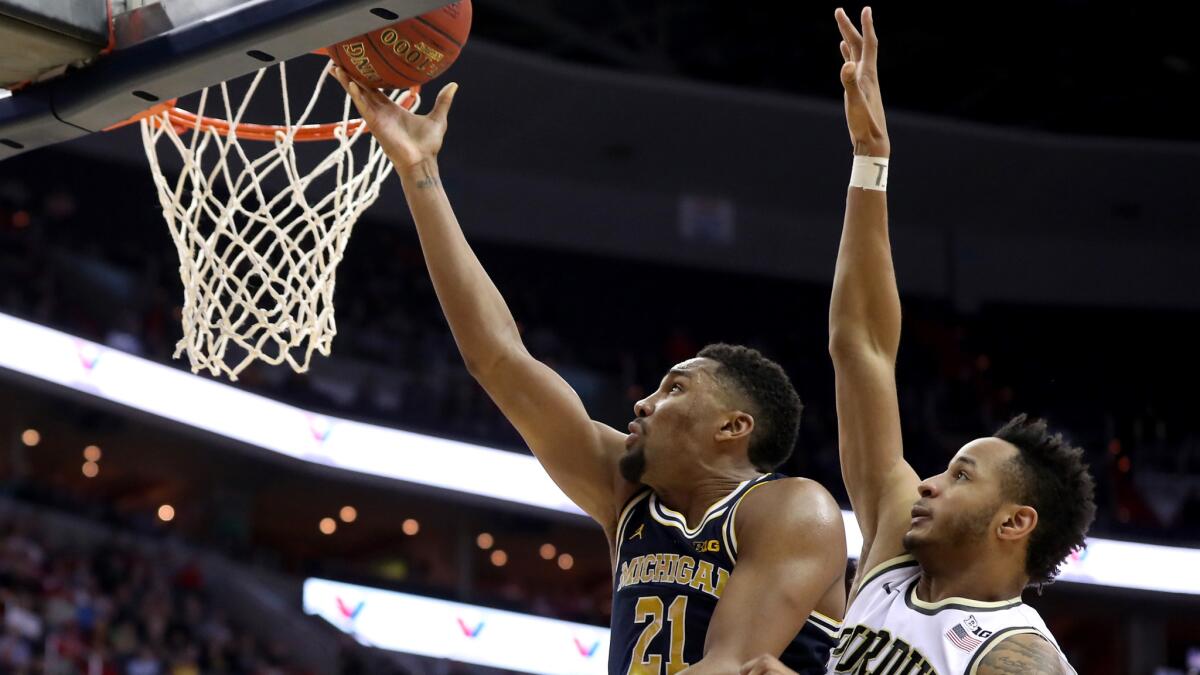 Michigan forward Zak Irvin scores against Purdue forward Vince Edwards in overtime during a Big Ten quarterfinal game Friday.