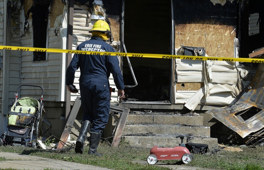 Erie Bureau of Fire Inspector Mark Polanski helps investigate a fatal fire in Erie, Pa., on Sunday. The early morning fire in Pennsylvania claimed the lives of five children and sent another person to the hospital.