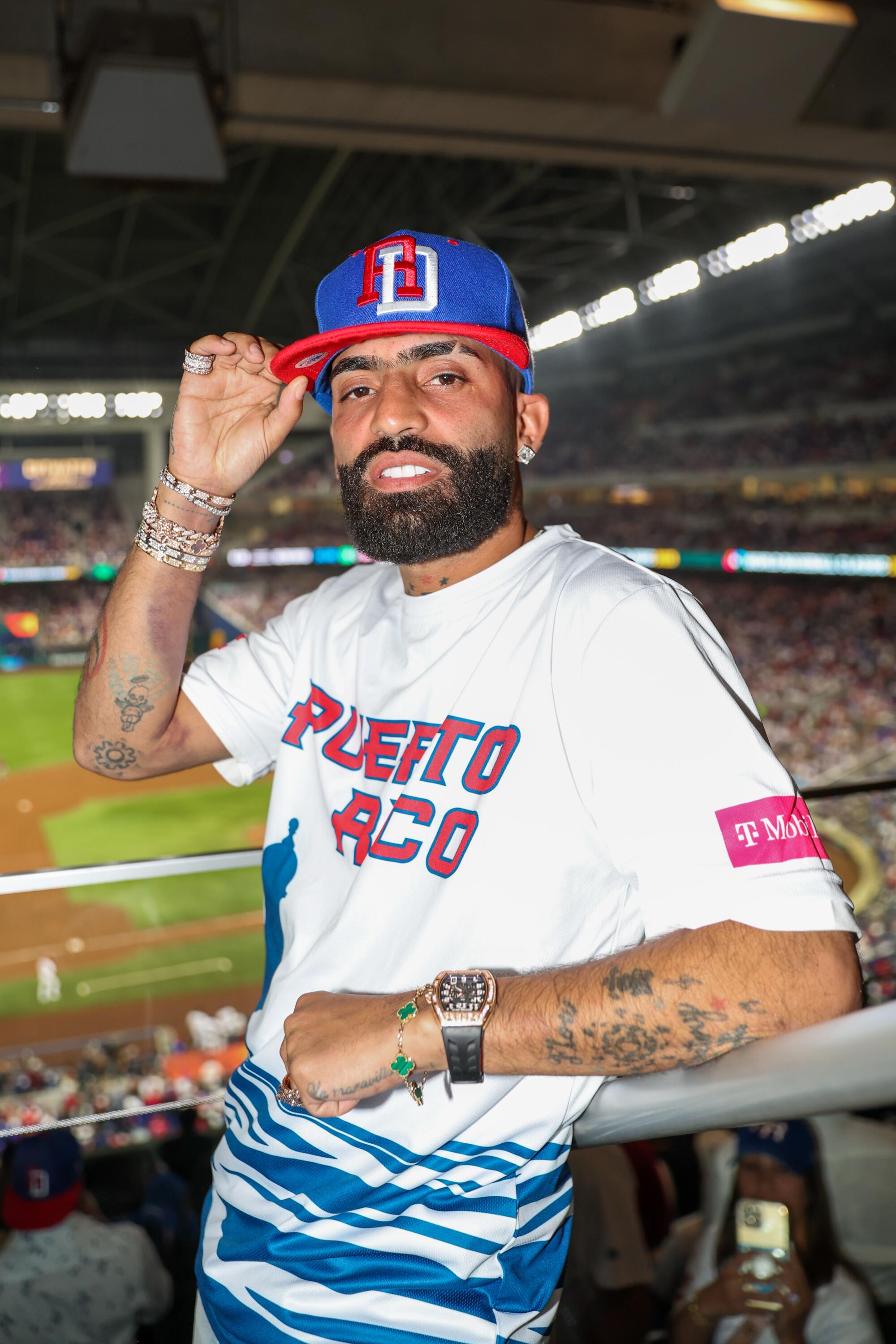 El reggaetonero Arcángel posa en las gradas del estadio en apoyo a Puerto Rico.