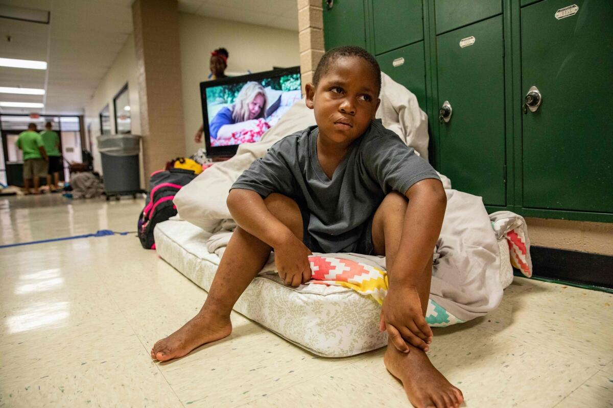 TOPSHOT - A child sits on a single mattress at a Hurricane Florence evacuation shelter at Conway High School on September 13, 2018 in Conway, South Carolina. - Hurricane Florence edged closer to the east coast of the US Thursday, with tropical-force winds and rain already lashing barrier islands just off the North Carolina mainland. The huge storm weakened to a Category 2 hurricane overnight, but forecasters warned that it still packed a dangerous punch, 110 mile-an-hour (175 kph) winds and torrential rains. (Photo by Alex Edelman / AFP)ALEX EDELMAN/AFP/Getty Images ** OUTS - ELSENT, FPG, CM - OUTS * NM, PH, VA if sourced by CT, LA or MoD **