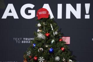 A Make America Great Again hat sits on top of a Christmas tree during a former President Donald Trump commit to caucus rally, Tuesday, Dec. 19, 2023, in Waterloo, Iowa. (AP Photo/Charlie Neibergall)