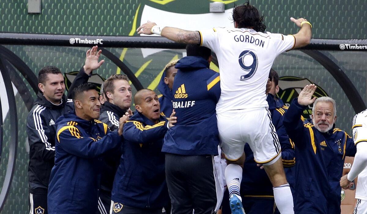 Los Angeles Galaxy forward Alan Gordon jumps in the arms of teammates after scoring a goal in extra time to tie the game against the Portland Timbers on Sunday.
