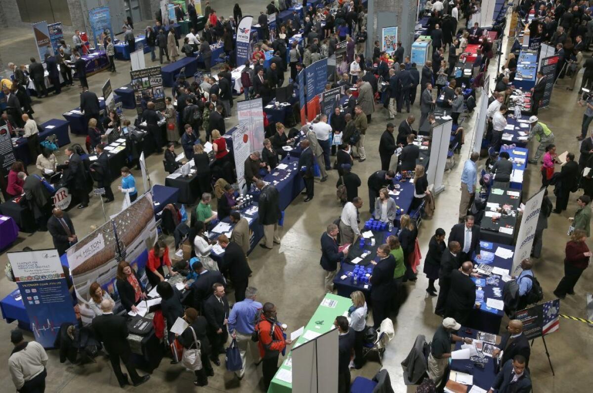 People visit booths of prospective employers during a job fair for veterans at the Washington Convention Center.