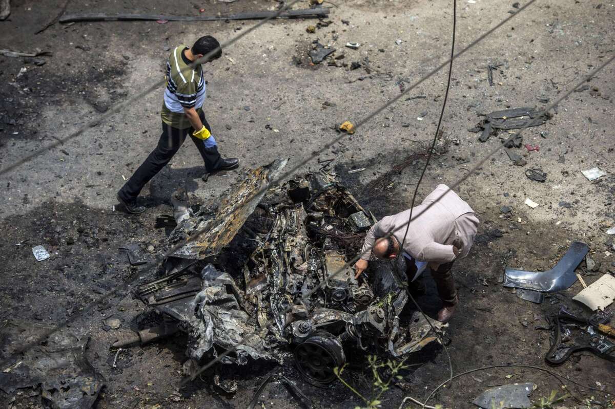 Forensic detectives work at the site of a bombing that targeted the convoy of the Egyptian state prosecutor, Hisham Barakat, in the Cairo suburb of Heliopolis on Monday.