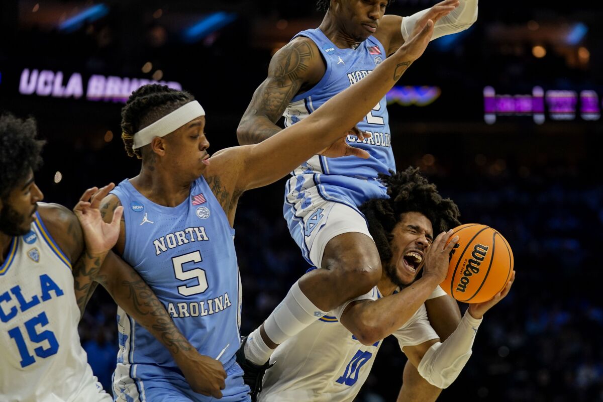 UCLA guard Tyger Campbell is fouled by North Carolina guard Caleb Love during the first half.