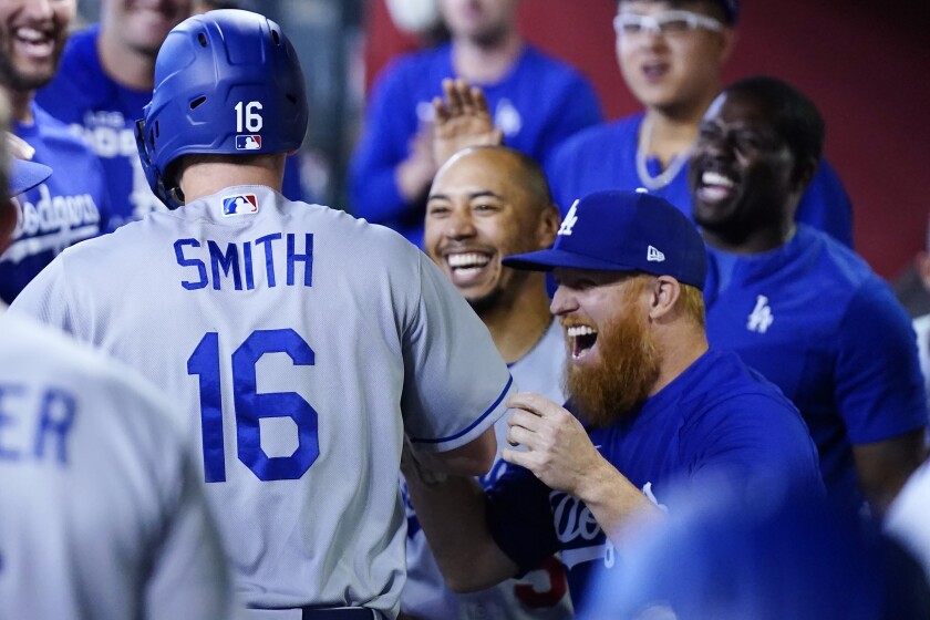Will Smith celebrates with teammates in dugout after hitting a home run for the Dodgers against the Diamondbacks on Sunday.