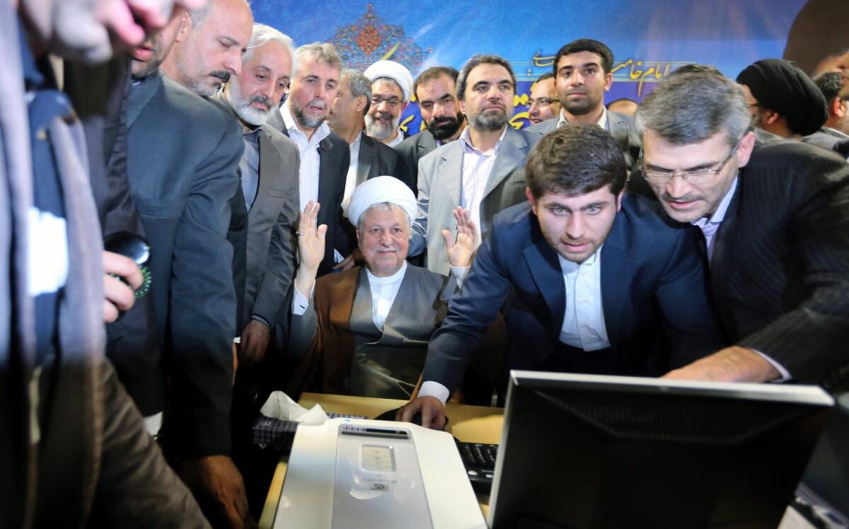 Iran's former president, Akbar Hashemi Rafsanjani, center, registers his candidacy for upcoming elections.
