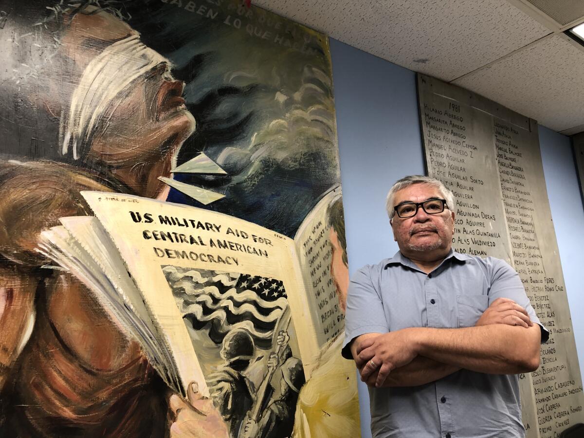 Immigrant rights activist Salvador Sanabria in front of a mural dedicated to the victims of the war in El Salvador.