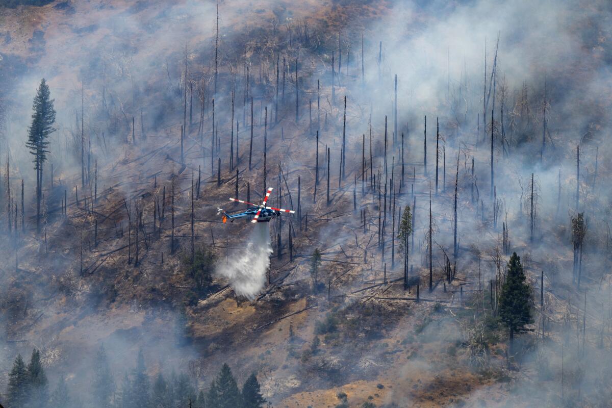 A helicopter drops water on the Park fire near Butte Meadows