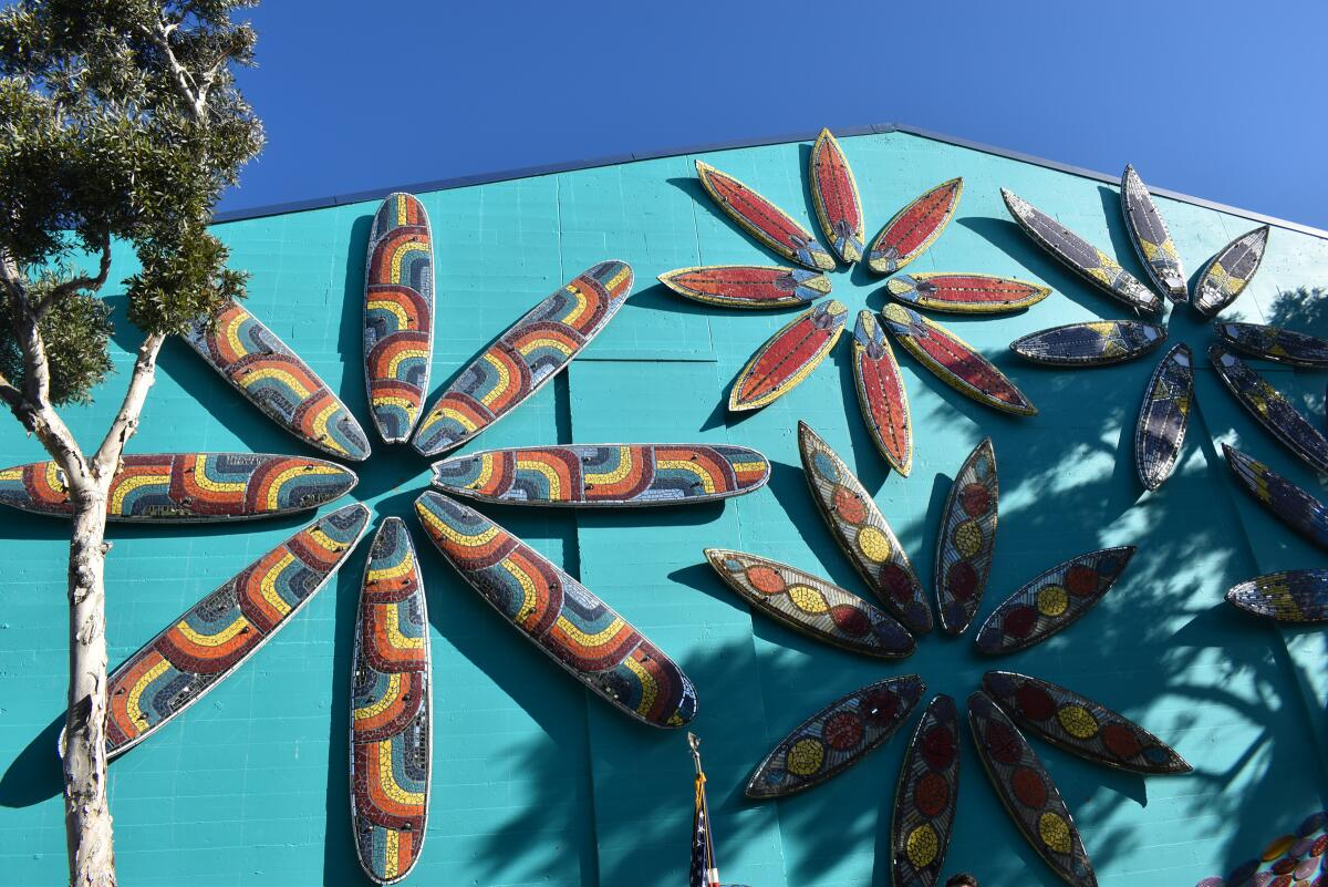 Each flower constructed on the PB Recreation Center’s north wall features a different mosaic design on the surf boards.