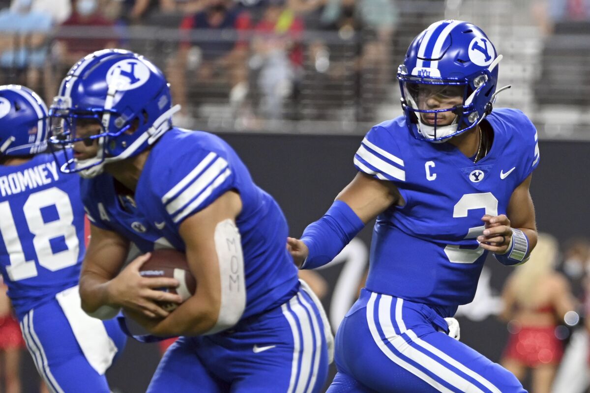BYU quarterback Jaren Hall (3) hands off to running back Lopini Katoa during the first half of the team's NCAA college football game against Arizona on Saturday, Sept. 4, 2021, in Las Vegas. (AP Photo/David Becker)