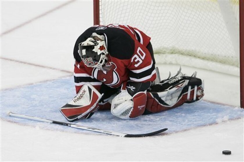 New Jersey Devils' Martin Brodeur (30) kneels after bruising his left elbow while making a save against the Atlanta Thrashers in the second period of an NHL hockey game in Newark, N.J. Saturday, Nov. 1, 2008. Brodeur left the ice and did not return for the remainder of the period. (AP Photo/Rich Schultz)