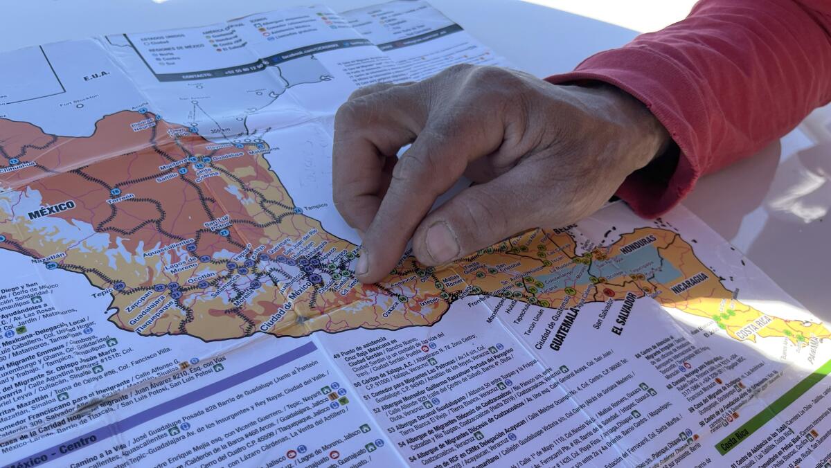 Robert Connell, a Venezuelan migrant in transit in Tijuana, points in the map 