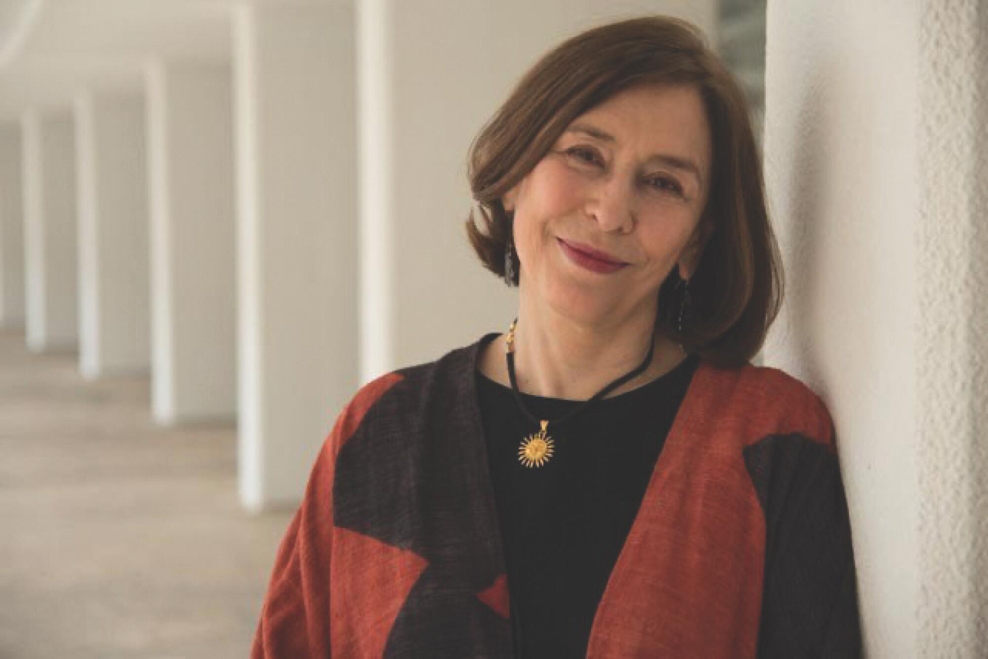 A portrait of Azar Nafisi against a backdrop of white pillars.