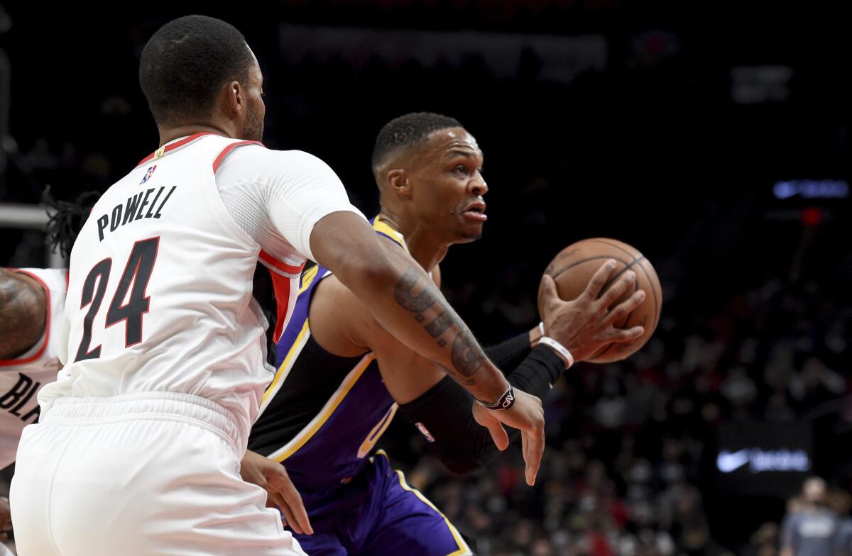 Lakers guard Russell Westbrook drives to the basket on Portland Trail Blazers forward Norman Powell.