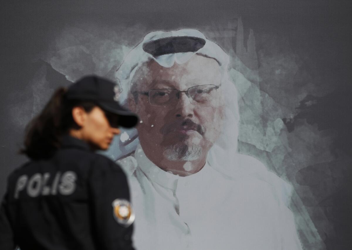 A Turkish police officer walks past a picture of slain Saudi journalist Jamal Khashoggi prior to a ceremony marking the one-year anniversary of his death