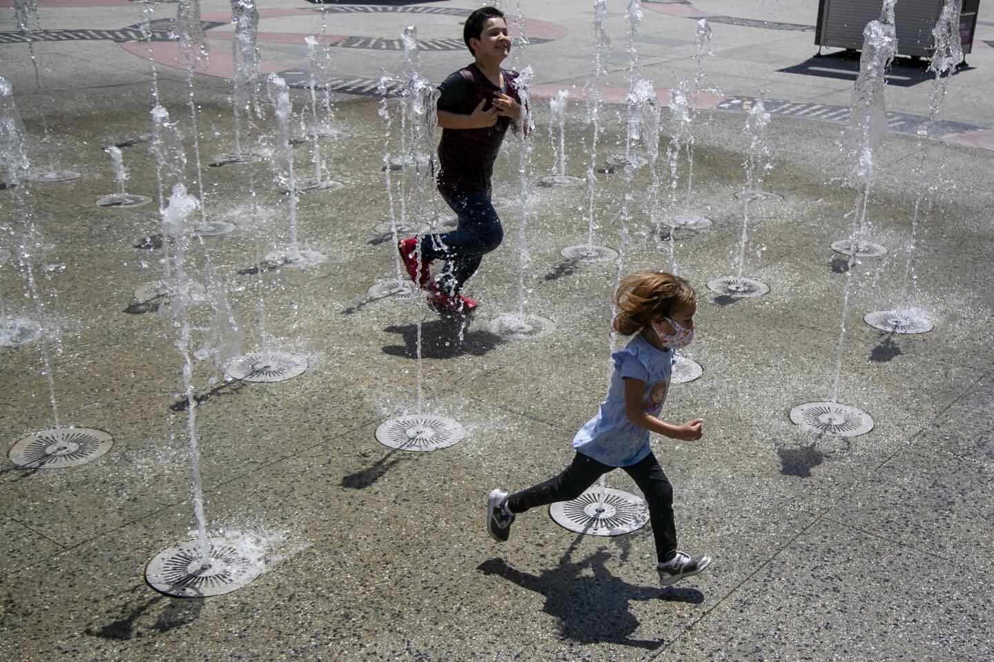 Two children run through a water fountain at Hollywood & Highland.