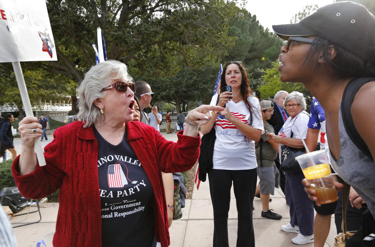 Carol Schlaepfer, left, from Chino Valley, argues with an unidentified U.C. Irvine student on campus during a protest Tuesday afternoon.