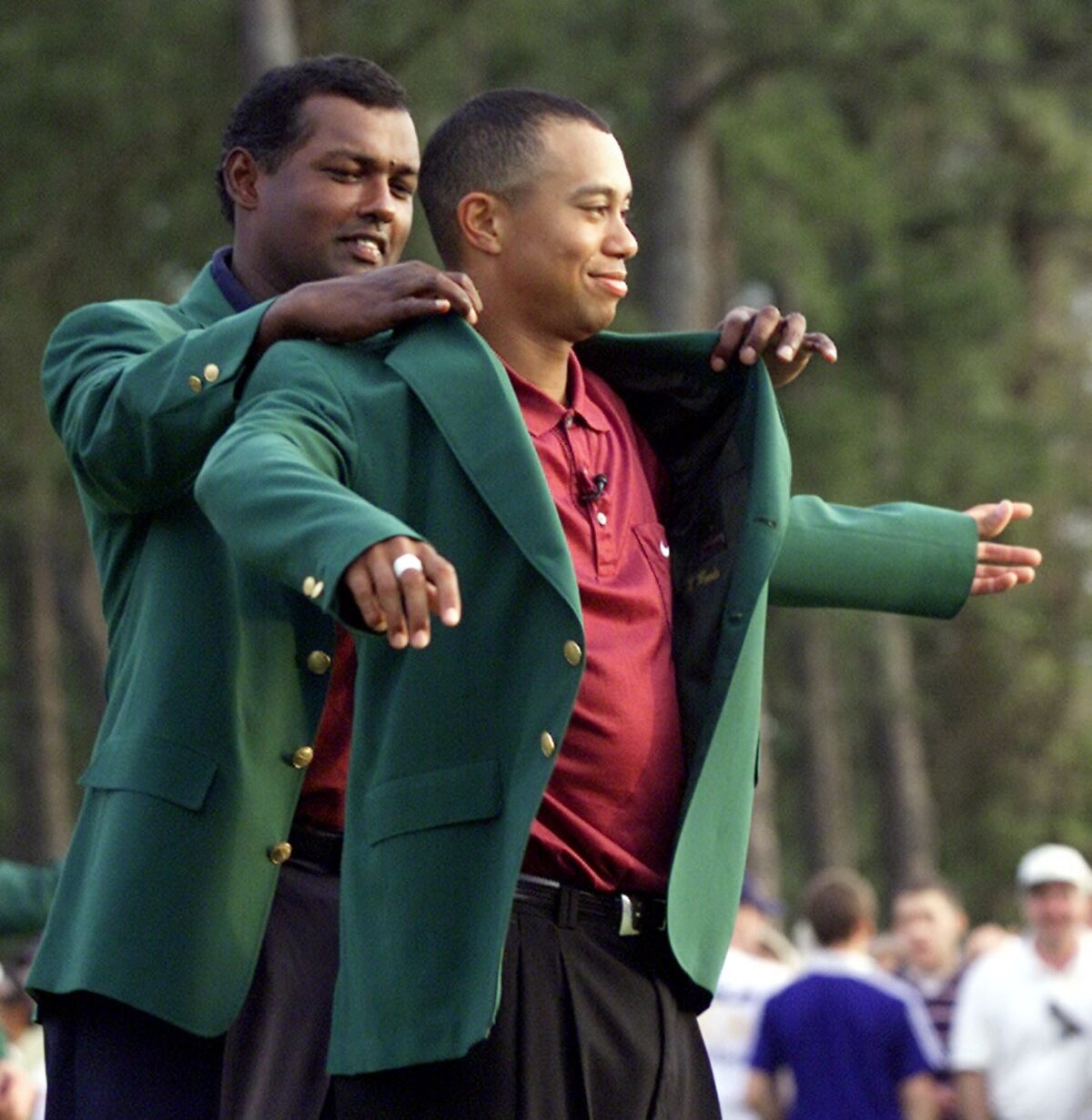 Tiger Woods, right, receives his Masters green jacket from 2000 champion Vijay Singh after winning the 2001 Masters at the Augusta National Golf Club in Augusta, Ga. on April 8, 2001.
