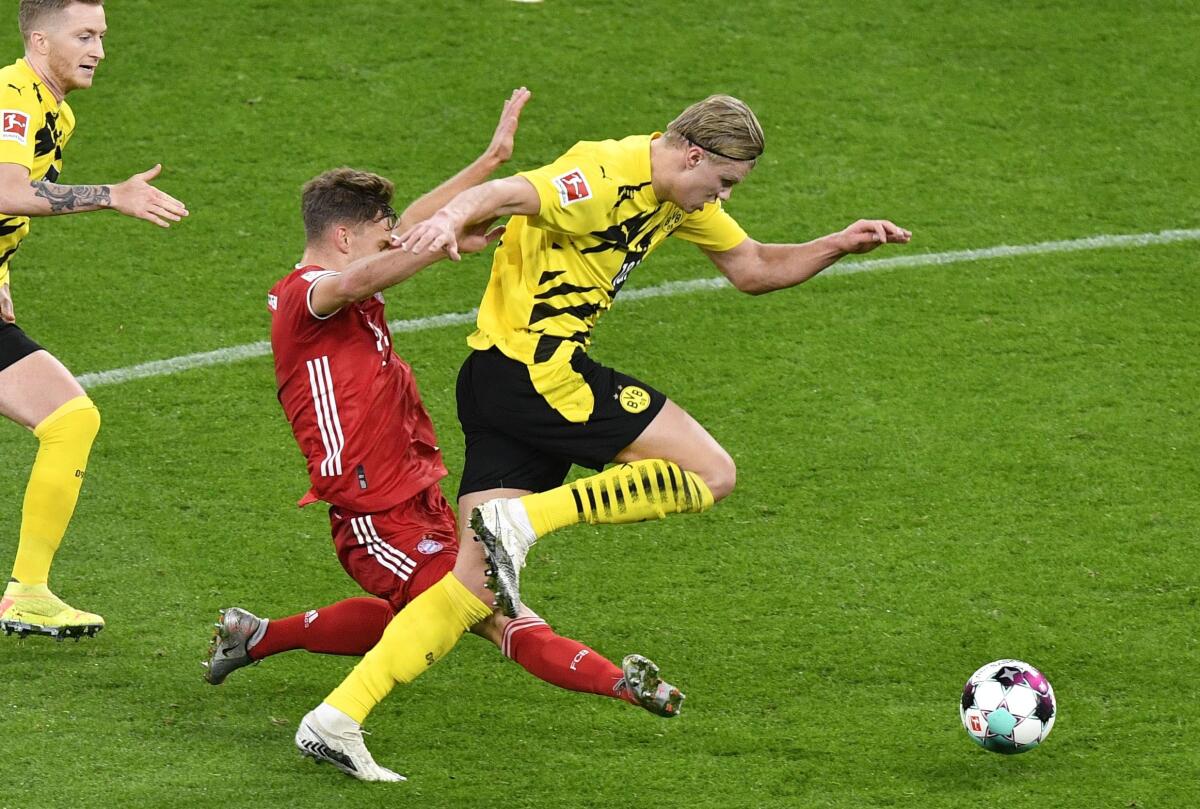 FILE - In this Saturday, Nov. 7, 2020 file photo Dortmund's Erling Haaland, right, and Bayern's Joshua Kimmich challenge for the ball during the German Bundesliga soccer match between Borussia Dortmund and Bayern Munich in Dortmund, Germany. The new Bundesliga season begins with Bayern Munich the favorite to win yet another title. Borussia Dortmund will also hope to challenge Bayern again this season. (AP Photo/Martin Meissner, file, Pool)