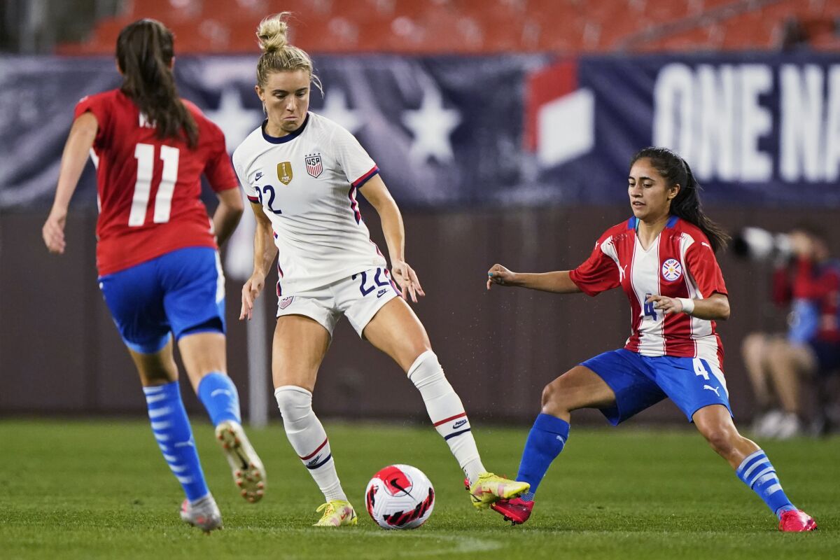 U.S. midfielder Kristie Mewis (22) moves the ball between Paraguay's Mirta Pico (11) and Daysy Bareiro (4) during the first half of an international friendly soccer match Thursday, Sept. 16, 2021, in Cleveland. (AP Photo/Tony Dejak)