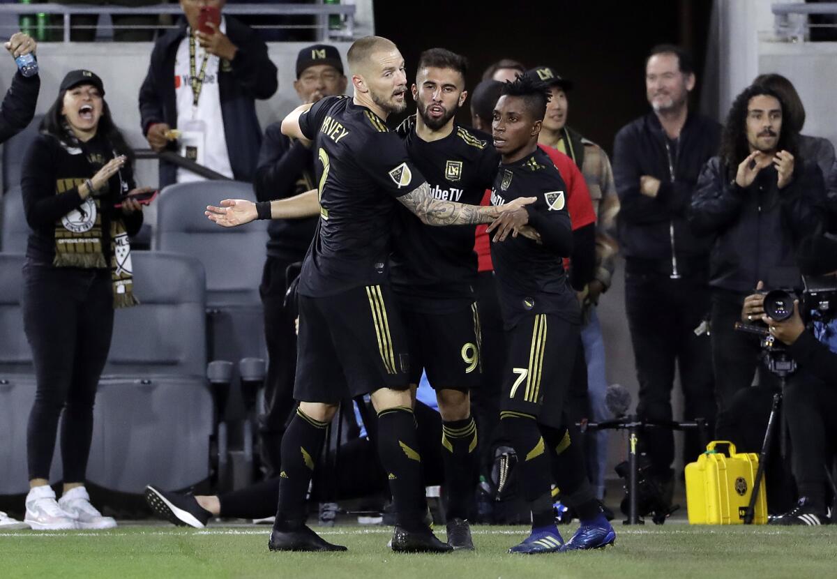 LAFC's Diego Rossi, center, is hugged by teammates Jordan Harvey, left, and Latif Blessing after a goal during the first half of a game this season.