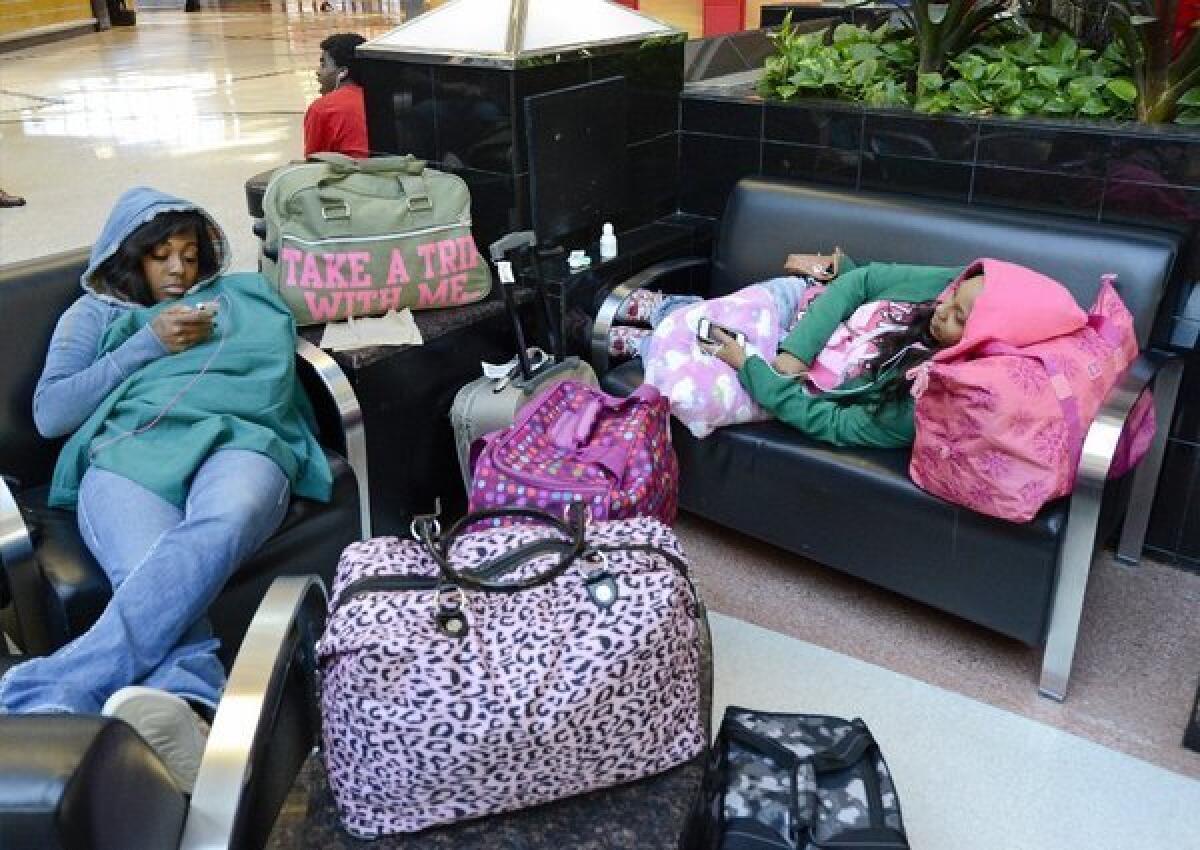 Thanks to Hurricane Sandy, Baltimore-bound travelers Nene Coleman, left, and Shan Dora are stranded at Hartsfield-Jackson Atlanta International Airport. Coleman said Monday that the airline might not be able to get them home until Nov. 1.