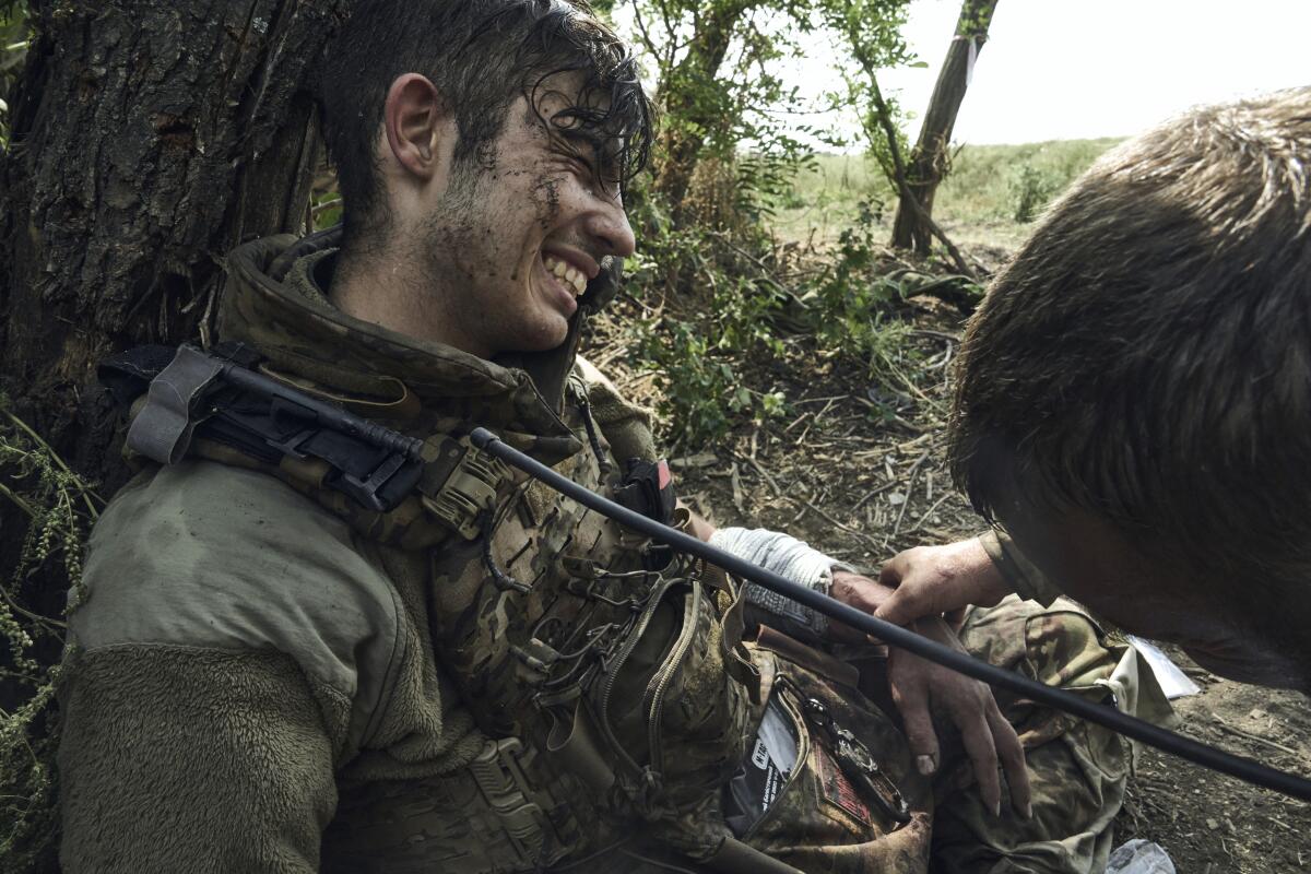 A Ukranian soldier gives first aid to his wounded comrade near Bakhmut, Ukraine, on Sept. 4.