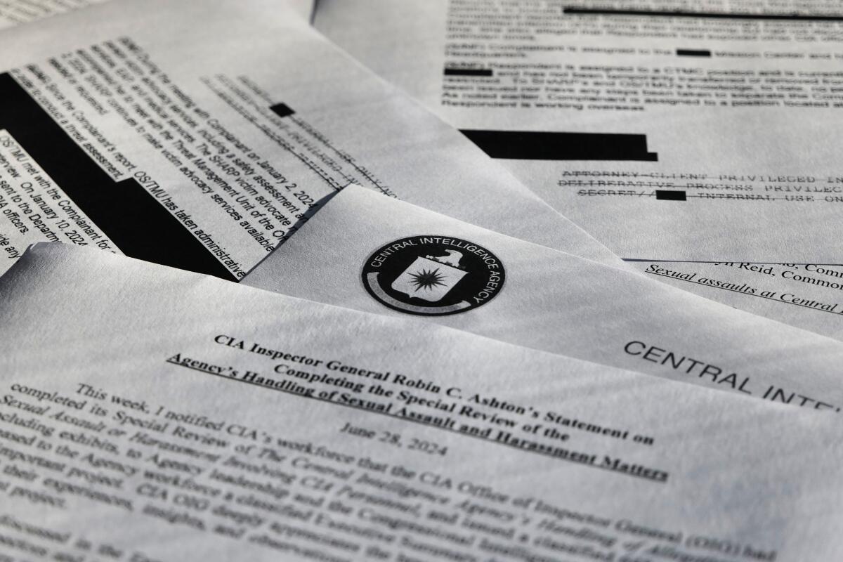 A pile of documents, some with redacted passages.