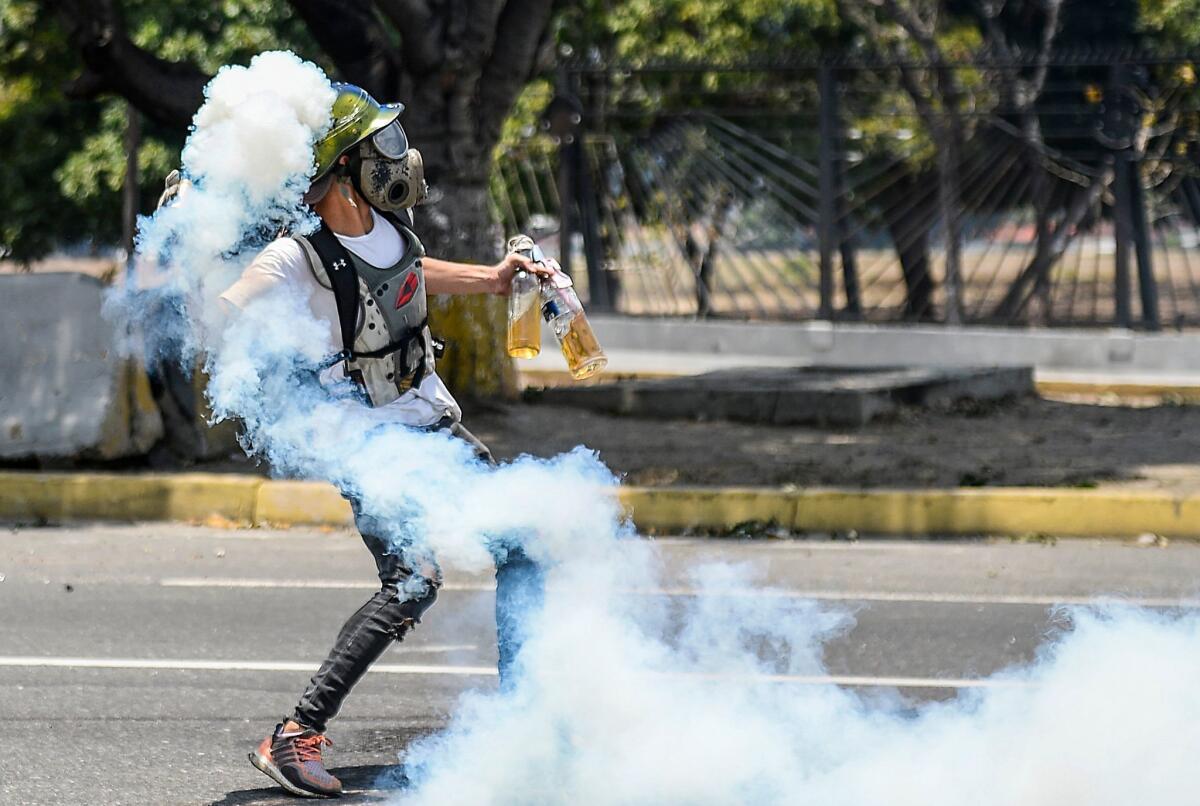 An anti-government protester throws Molotov cocktails during a clash with security forces near La Carlota military base in Venezuela's capital, Caracas, on Wednesday.