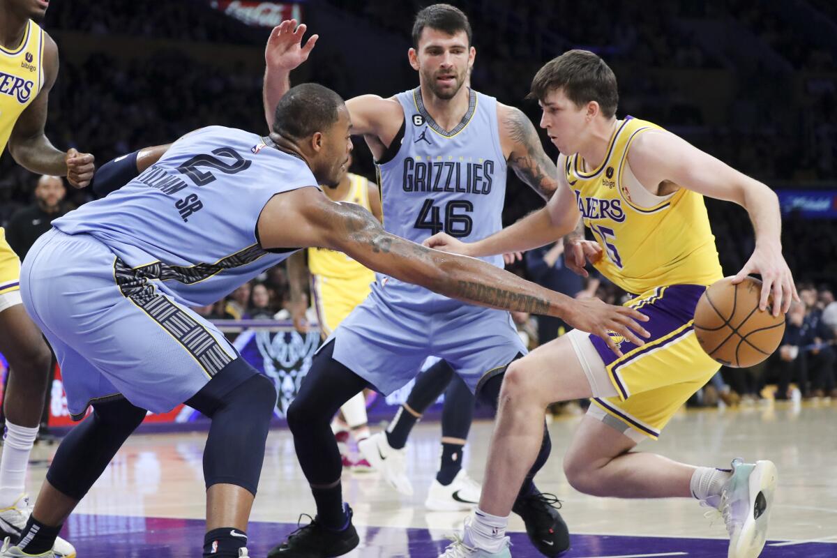 Lakers guard Austin Reaves handles the ball while Memphis Grizzlies forward Xavier Tillman and guard John Konchar defend.