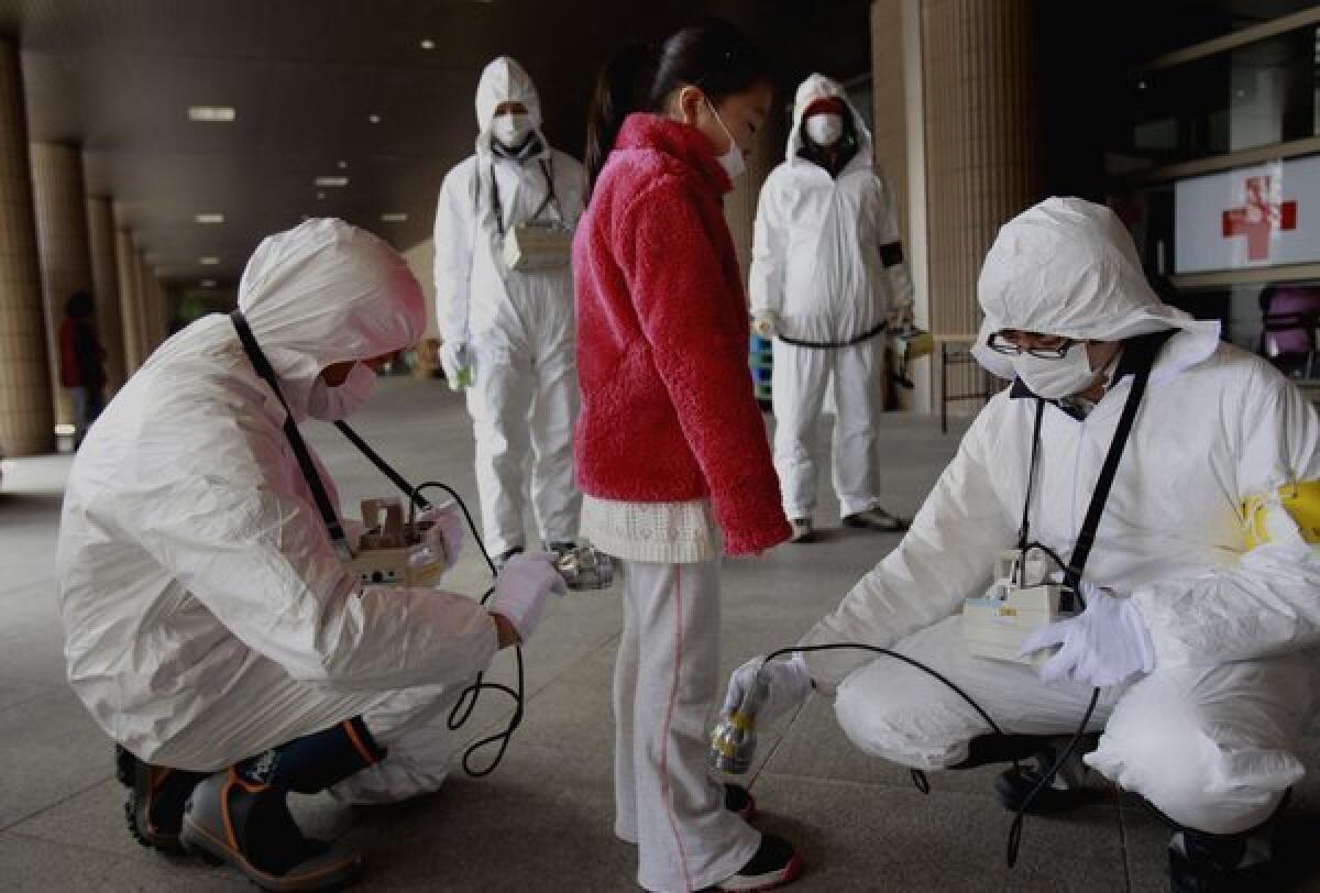 A young evacuee is screened at a shelter for radiation after a nuclear plant was damaged in Fukushima, Japan.