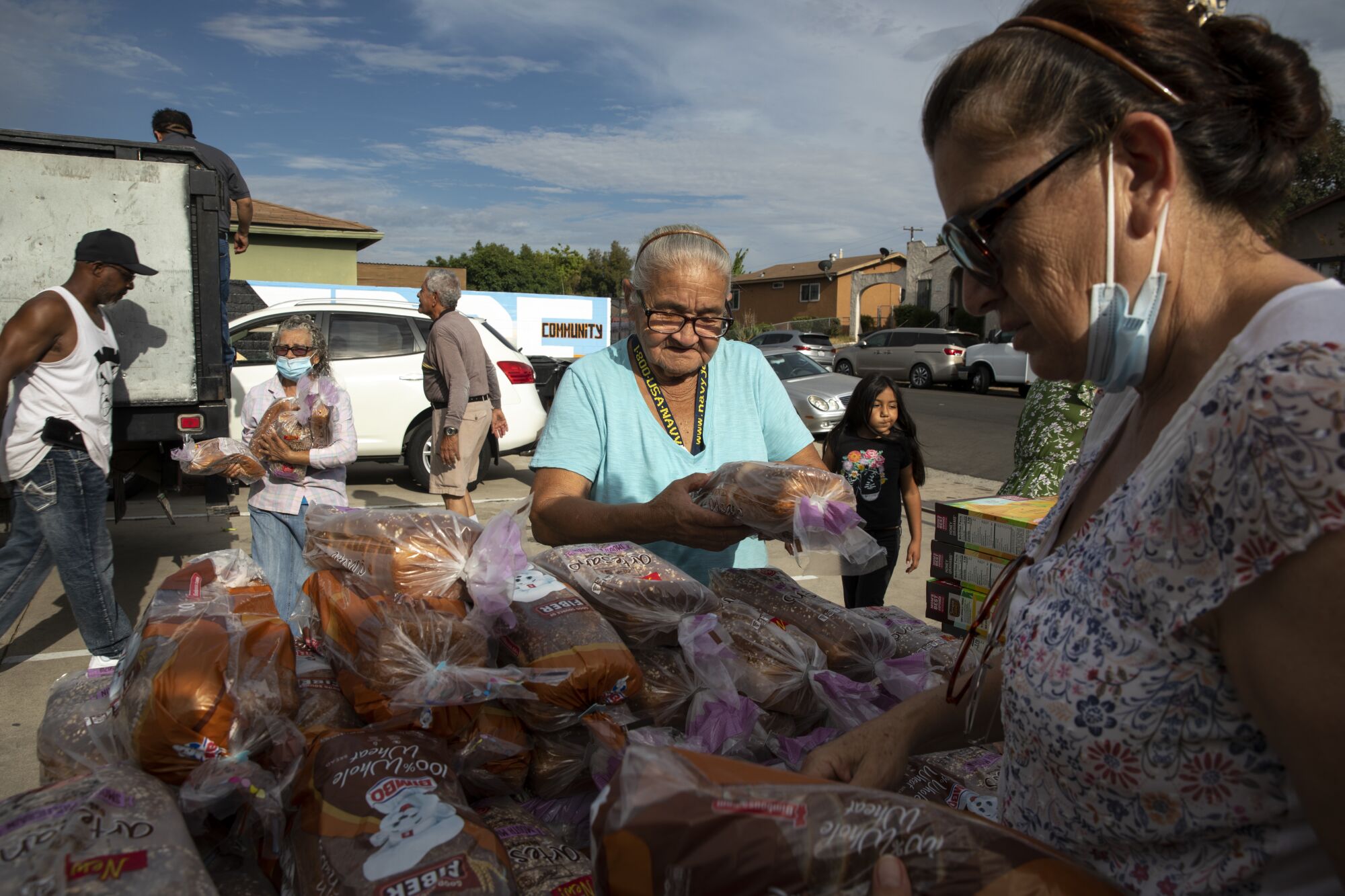 Community members line up for a weekly food bank in August.