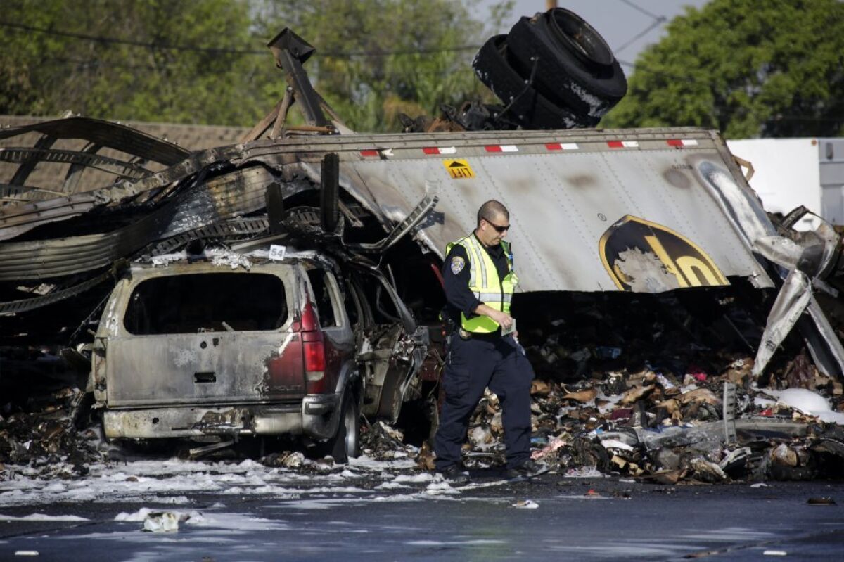 A California Highway Patrol investigator at the scene of a multi-vehicle crash on the 5 Freeway in Commerce on Saturday. Three people died in the crash, with others wounded.