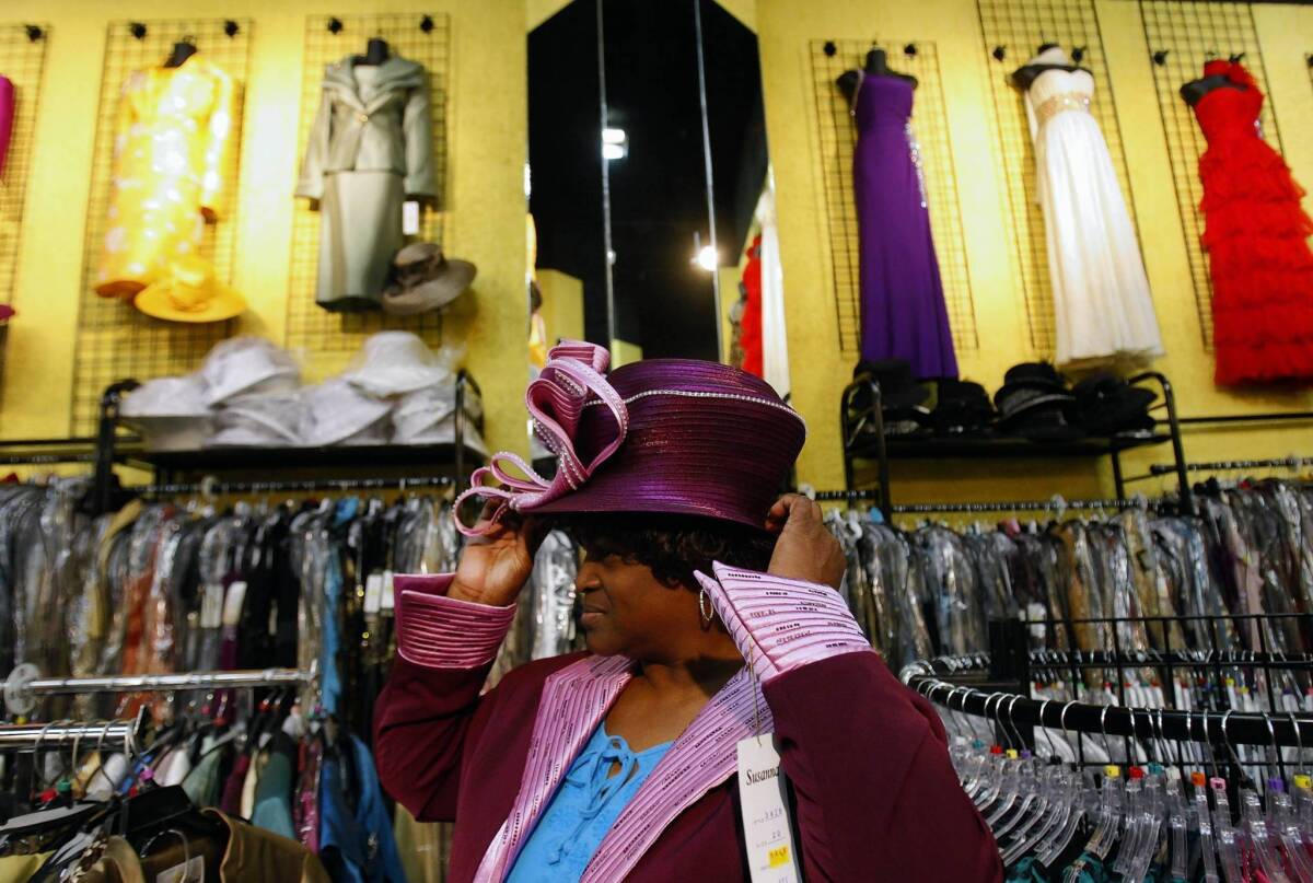 Ruby Smith tries on a hat at Divas, Ebby Tabarai's clothing store in downtown Los Angeles.
