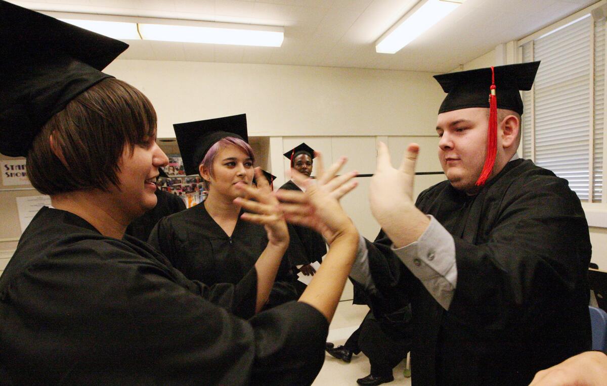 Ren Stewart and Andrew Pulido play a game with Keeley Booth watching before the Monterey High graduation ceremony on Wednesday, June 11, 2014.