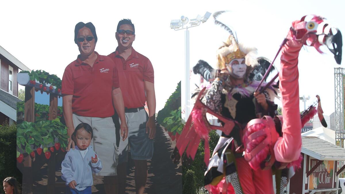 The faces of Glenn Tanaka and his son, Kenny, of Tanaka Farms, greet fairgoers at the main entrance as part of the "Bounty of the County" series of 16-foot murals.