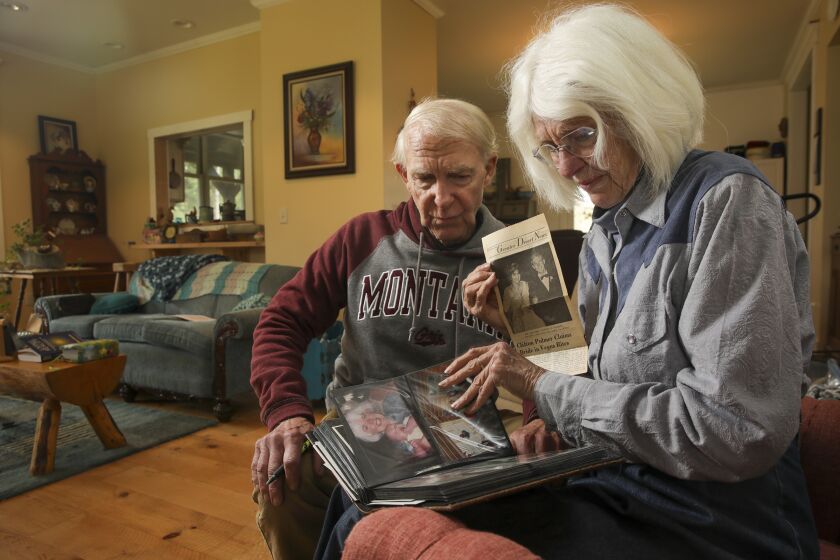 Bigfork, Montana - May 17: Cliff Palmer, 77, left, and Cheryl Palmer, 78, were college friends in 1966 when they learned Cheryl was pregnant. Both in fear of having a child terminated the pregnancy. Palmers go over old photos and newspaper clipping at their home on Tuesday, May 17, 2022 in Bigfork, Montana. (Irfan Khan / Los Angeles Times)