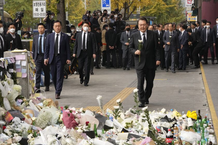 El presidente surcoreano Yoon Suk Yeol, derecha, rinde homenaje a las víctimas de una estampida letal ocurrida durante las festividades de Halloween en una calle cercana al lugar de la tragedia, el martes 1 de noviembre de 2022, en Seúl, Corea del Sur. (AP Foto/Ahn Young-joon)