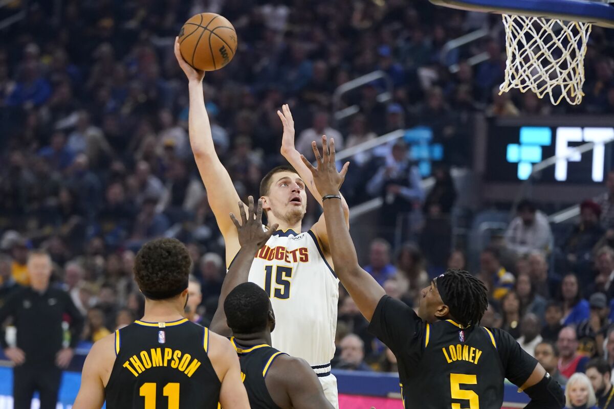 Denver Nuggets center Nikola Jokic (15) shoots against the Golden State Warriors during the first half of Game 1 of an NBA basketball first-round playoff series in San Francisco, Saturday, April 16, 2022. (AP Photo/Jeff Chiu)