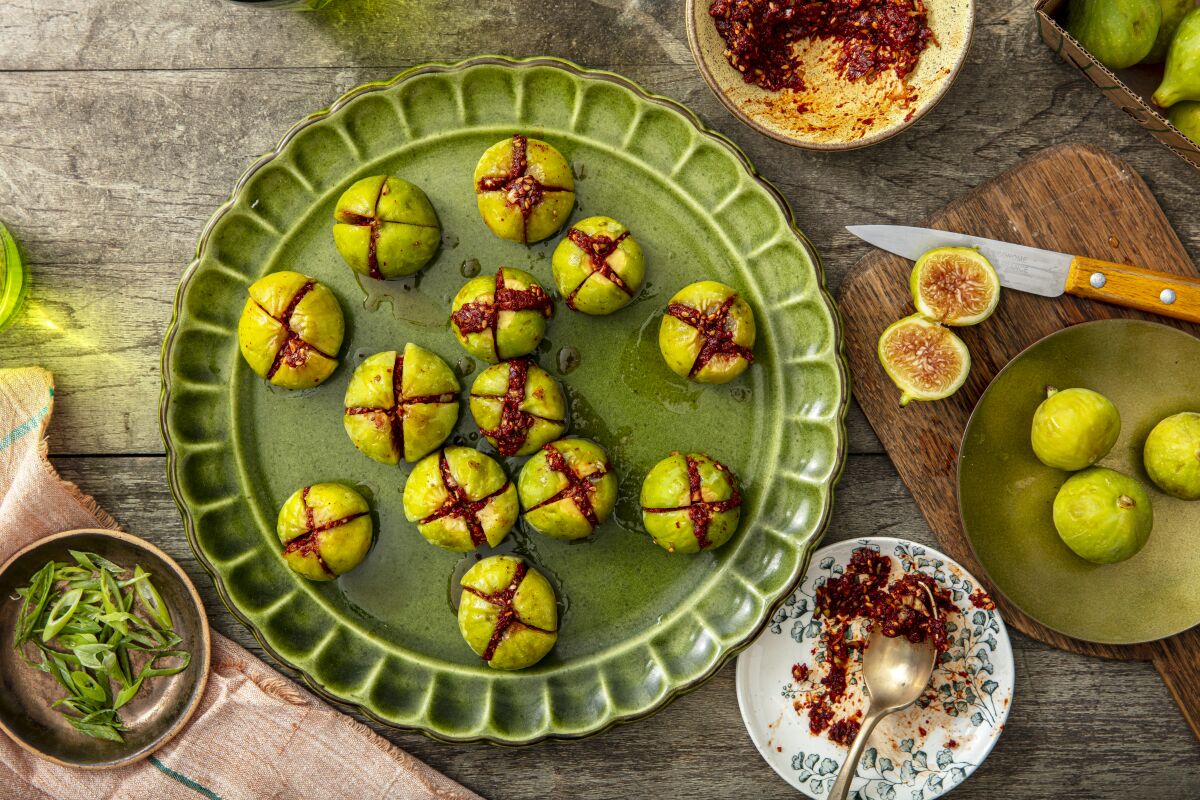 Figs with a kimchi filling, sitting on a green plate.