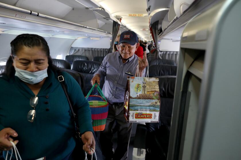 LOS ANGELES, CALIF. -- THURSDAY, FEBRUARY 13, 2020: Rafael and Lucia, left, Garcia, of San Fernando, with over 85 pieces of Pollo Campero fried chicken on an Avianca flight from El Salvador to Los Angeles, on Feb. 13, 2020. The Garcia's are originally from El Salvador and bring back the chicken for family and friends. They spent a month there on vacation. Pollo Campero restaurants are all over Los Angeles and the country and people still bring it back from Central America. (Gary Coronado / Los Angeles Times)
