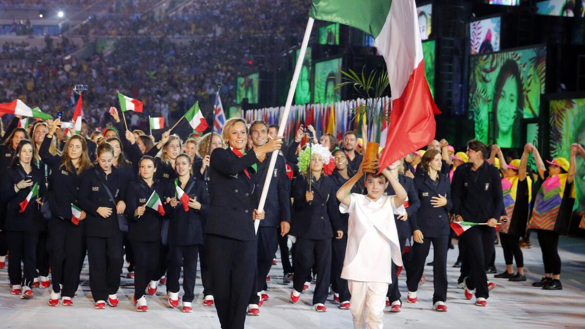 Swimmer Federica Pellegrini and a Brazilian youth lead Italy into the opening ceremony.