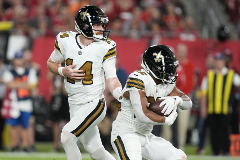 New Orleans Saints quarterback Andy Dalton (14) hands off to running back Mark Ingram II (22) in the first half of an NFL football game in Tampa, Fla., Monday, Dec. 5, 2022. (AP Photo/Chris O'Meara)