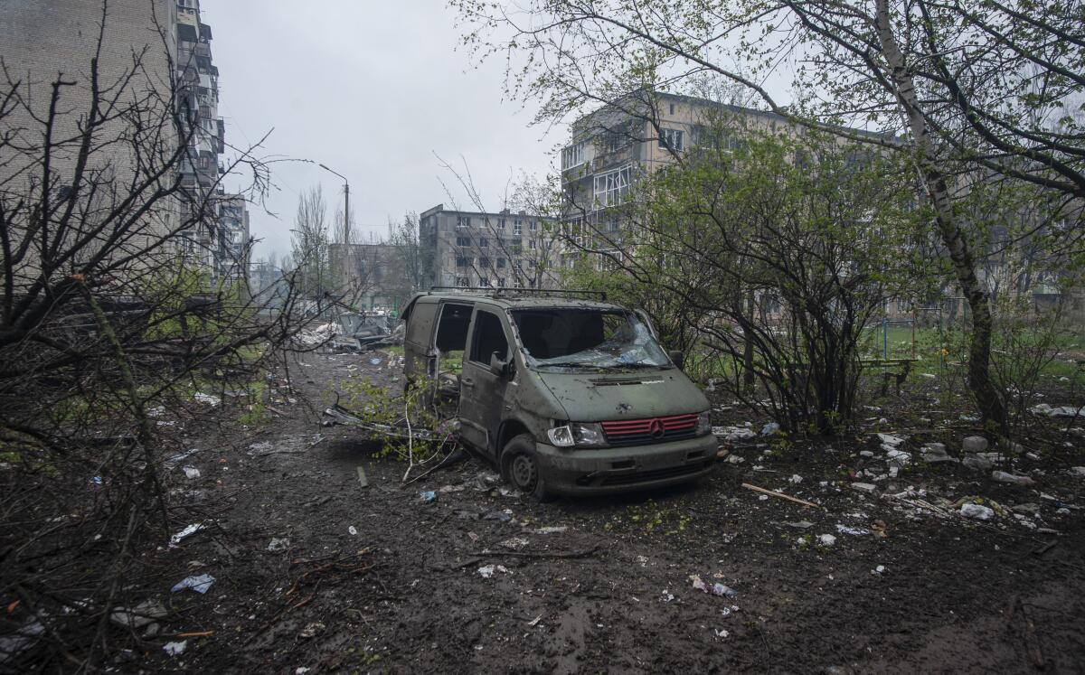 The shell of a van in a debris-littered area of Bakhmut, Ukraine, the site of heavy battles with Russian troops.