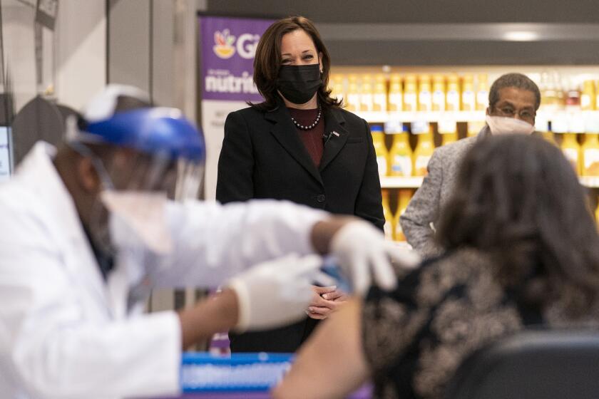 Vice President Kamala Harris watches as physician Linval Matthews, left, administers a Moderna COVID-19 vaccine to Brenda Thompson, right, at a Giant Foods grocery store, Thursday, Feb. 25, 2021, in Washington, as Delegate Eleanor Holmes Norton, D-D.C., background right, looks on. (AP Photo/Andrew Harnik)