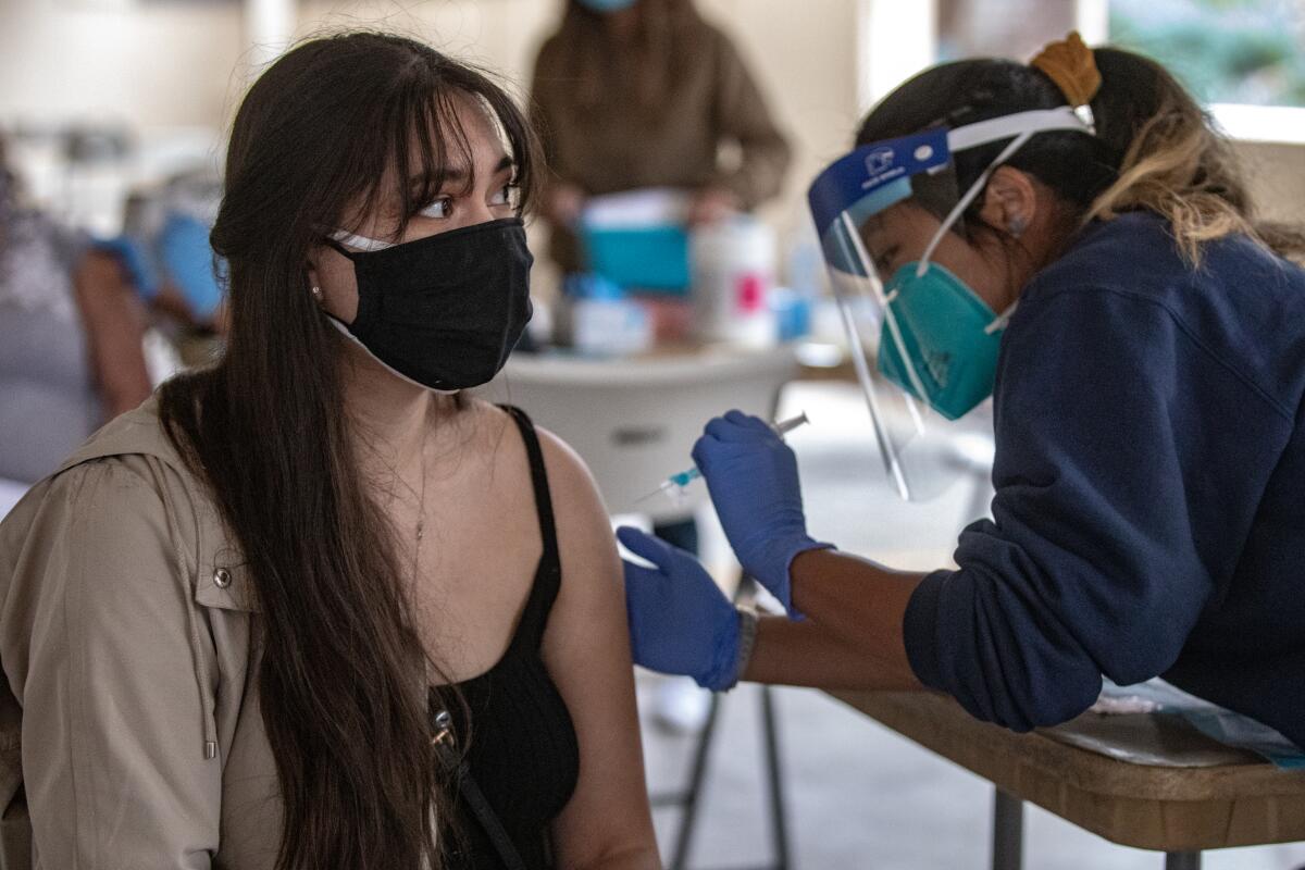 A woman receives a COVID-19 vaccine dose at the American Indian Health Center in San Diego on March 3. 