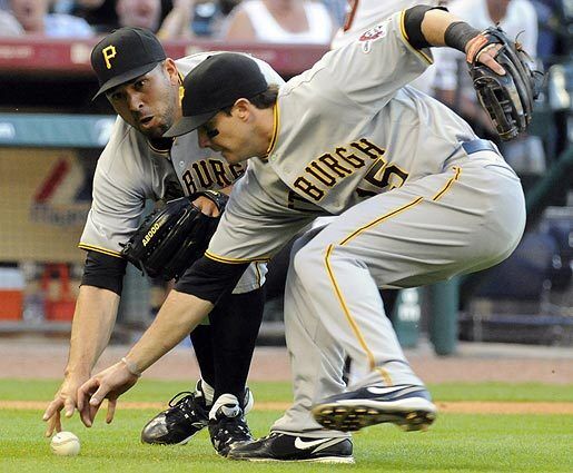 Pittsburgh Pirates pitcher D.J. Carrasco, left, and third baseman Andy LaRoche reach for the ball on a bunt by the Houston Astros' Wandy Rodriguez after Carrasco bobbled it for an error in the fourth inning of a baseball game.