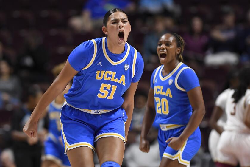 UCLA center Lauren Betts (51) and UCLA guard Charisma Osborne (20) react.